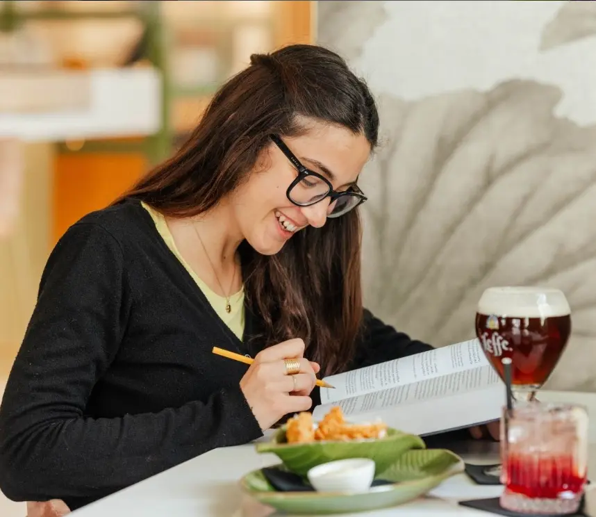 Studentessa legge e studia a un tavolo da Tàstiko